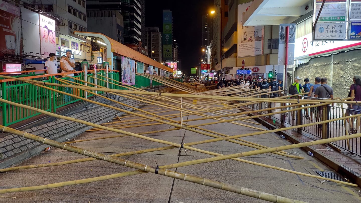 Protesters in HK set up bamboo road blocks.