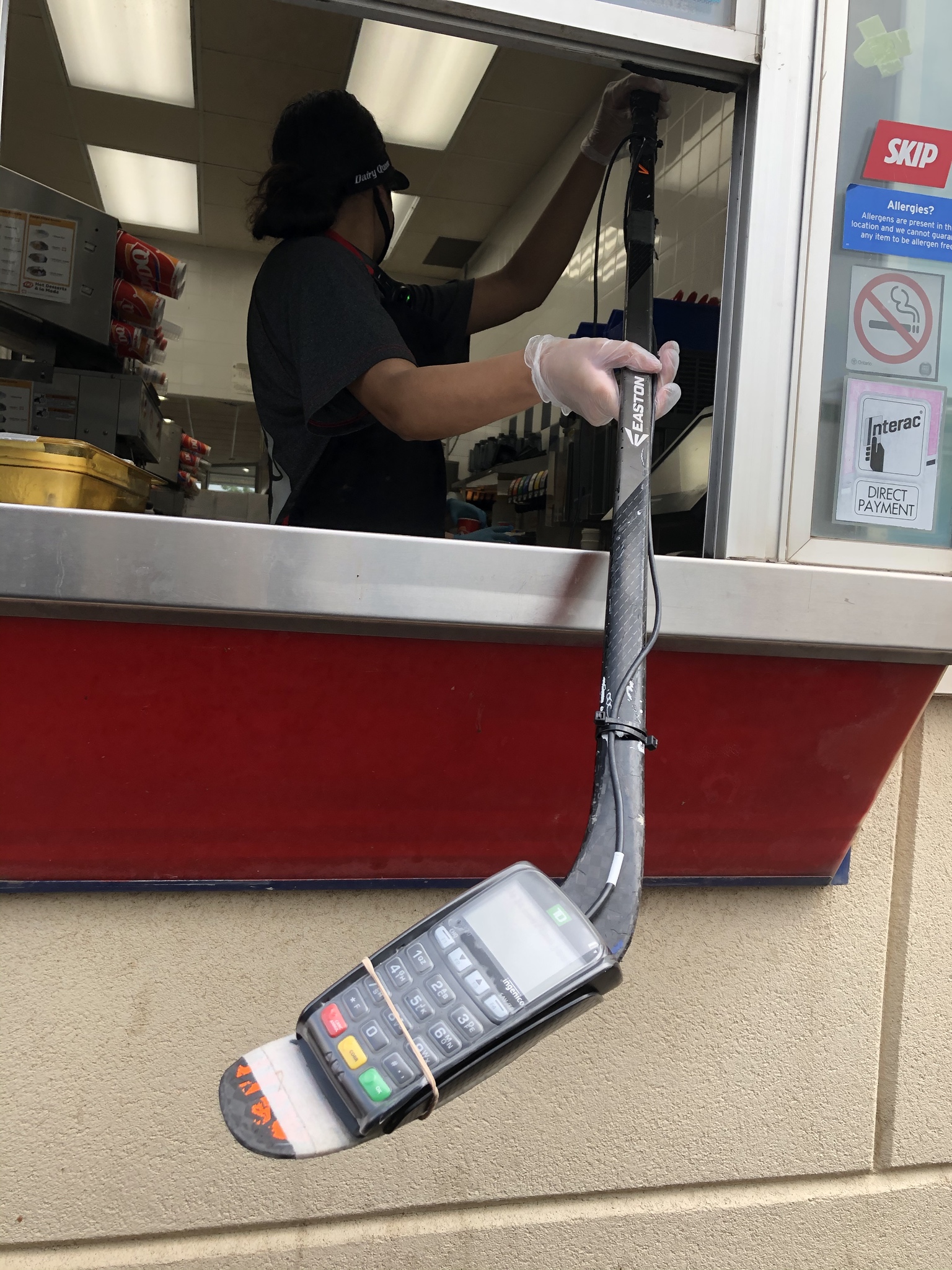 Dairy Queen Canada using a hockey stick for socially distance payments.