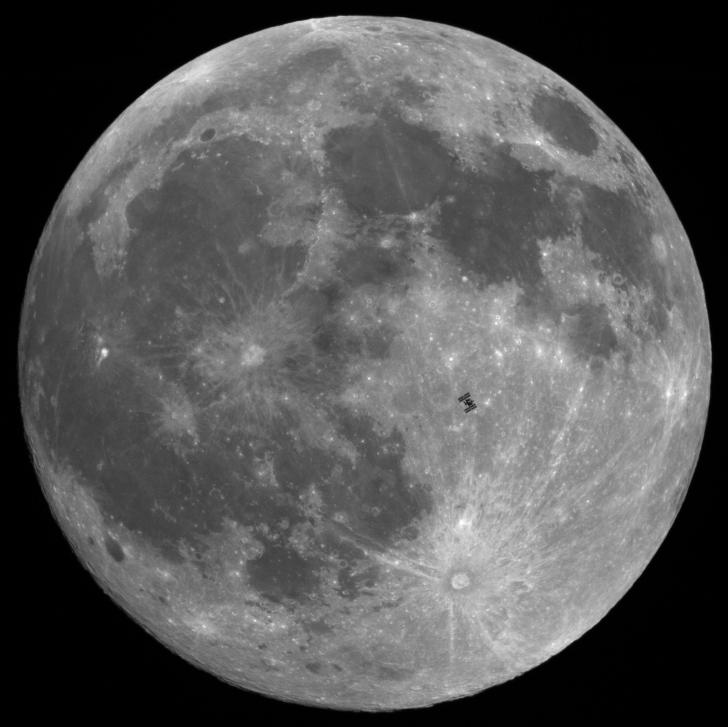 The International Space Station in front of the full moon.