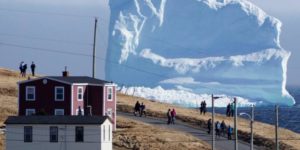 Residents watch an iceberg as it passes "Iceberg Alley" in Newfoundland, Canada