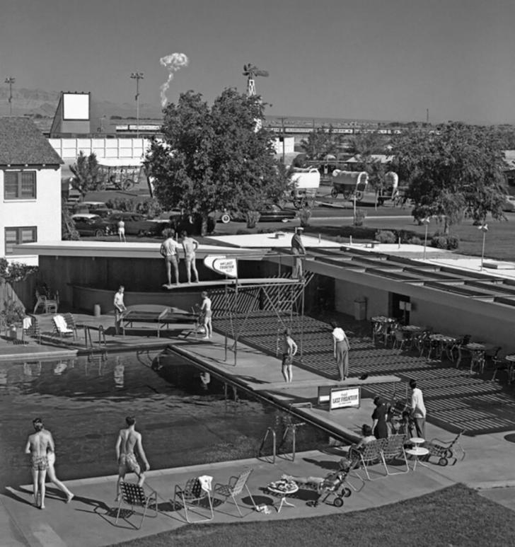 Swimmers at a Las Vegas hotel watch a mushroom cloud from an atomic test 75 miles away, 1953