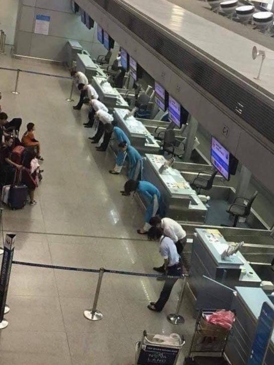 Flight delayed in Japan. Airline employees bow to the passengers to apologise.