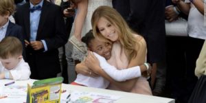 Smiling little girl enjoying a hug from the First Lady.