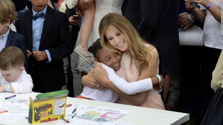 Smiling little girl enjoying a hug from the First Lady.