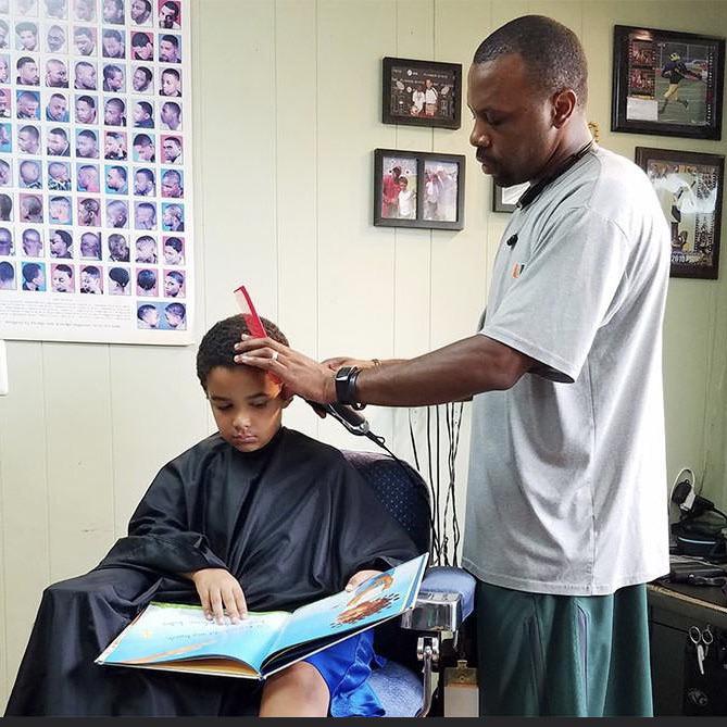 He gives kids a $2 discount if they read a book out loud during their haircut.