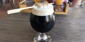 A s’mores porter with a burnt marshmallow stuck in it.