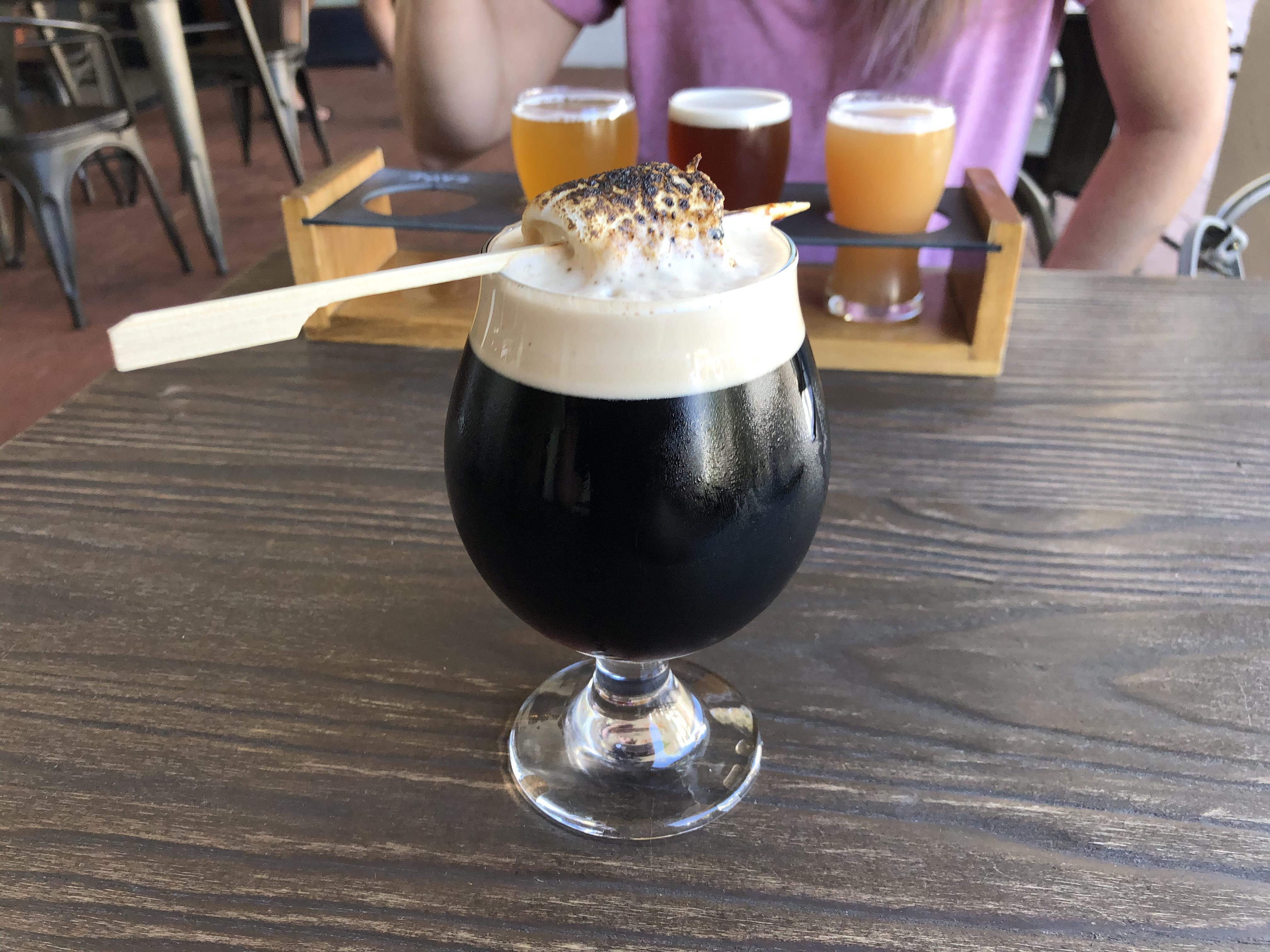A s'mores porter with a burnt marshmallow stuck in it.