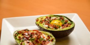 Eggs on Avocado with bacon, reggiano parmigiano and sirracha.