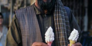 Afghan man holding his ice cream cones, Puli Khumri, Afghanistan.