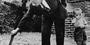 Martin Luther King with his son removing a burnt cross from their front yard