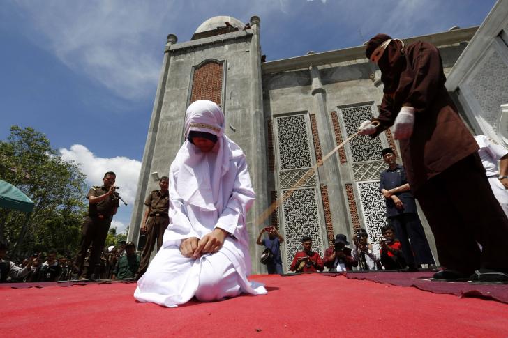An Indonesian girl being publicly whipped for violating Shari'a law.