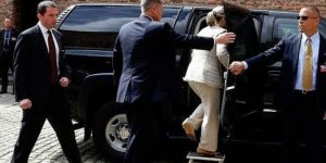 Hillary Clinton using a footstool to enter her car