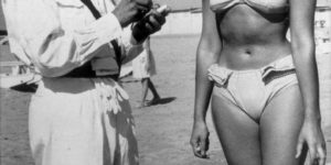 A Police officer issuing a woman a ticket for wearing a bikini on a beach at Rimini, Italy, in 1957