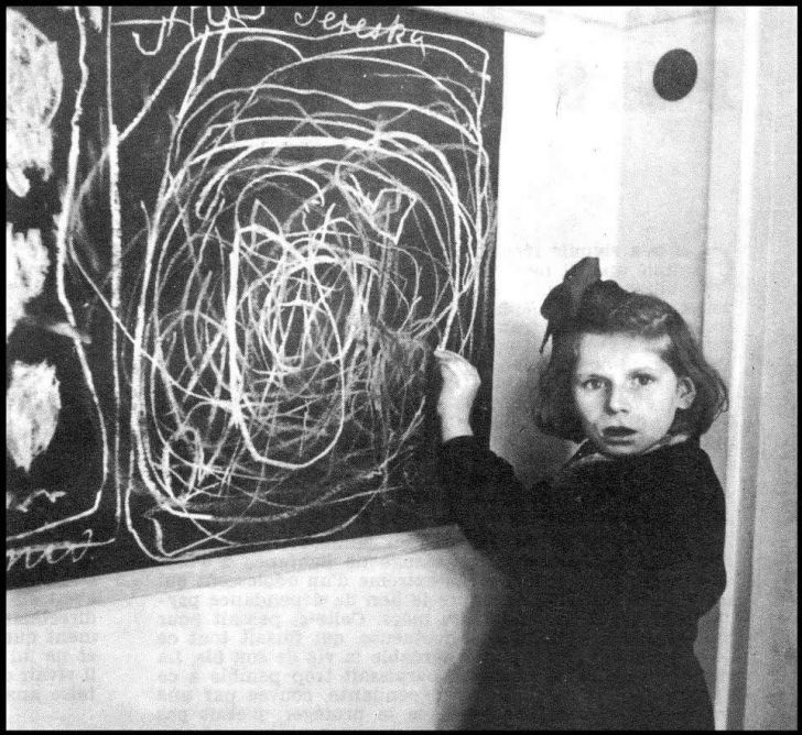 A girl who grew up in a concentration camp draws a picture of 'Home' while living in a residence for disturbed children. Poland, 1948.