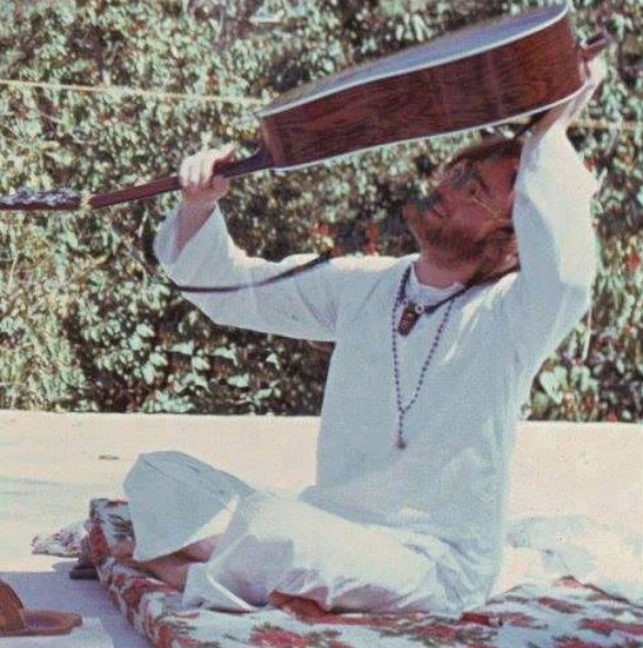 John Lennon losing his guitar pick in his guitar, India, 1968.