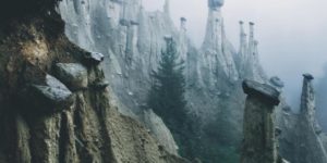 Rocks perched on eroded pillars of dirt in the Italian Alps