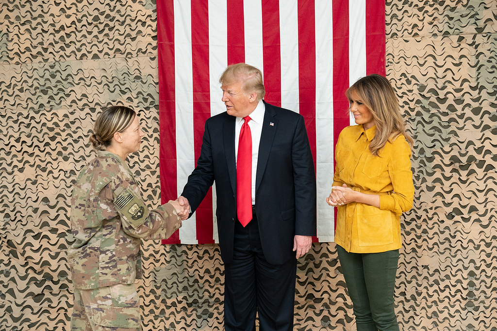 Mr. Trump practices his handhake before meeting with members of the military in Iraq