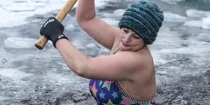 Using a sledgehammer to break up the ice in the Scottish Highlands before her morning swim