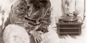 A proper Eskimo man hearing music on a record player for the first time, circa 1920.