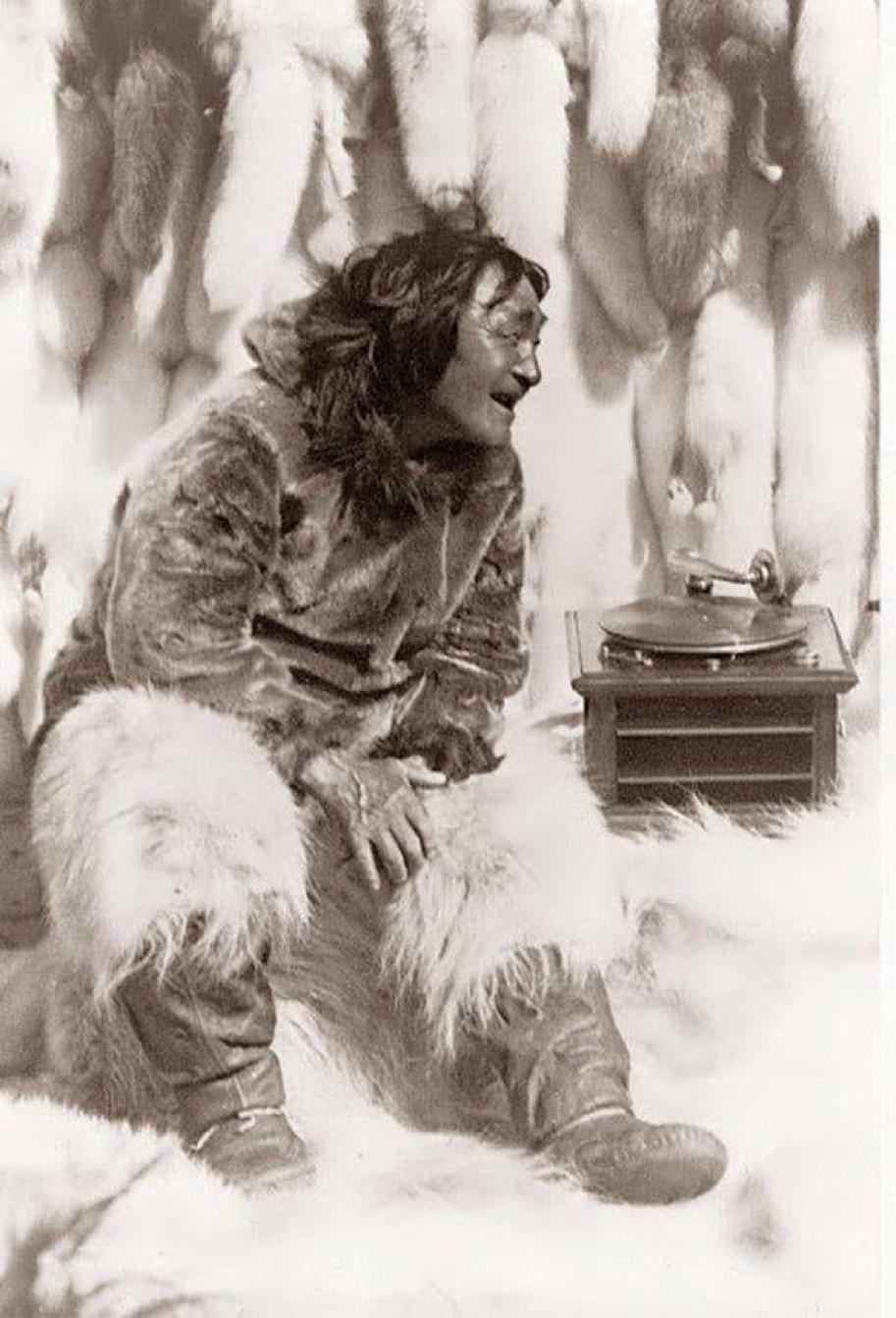 A proper Eskimo man hearing music on a record player for the first time, circa 1920.