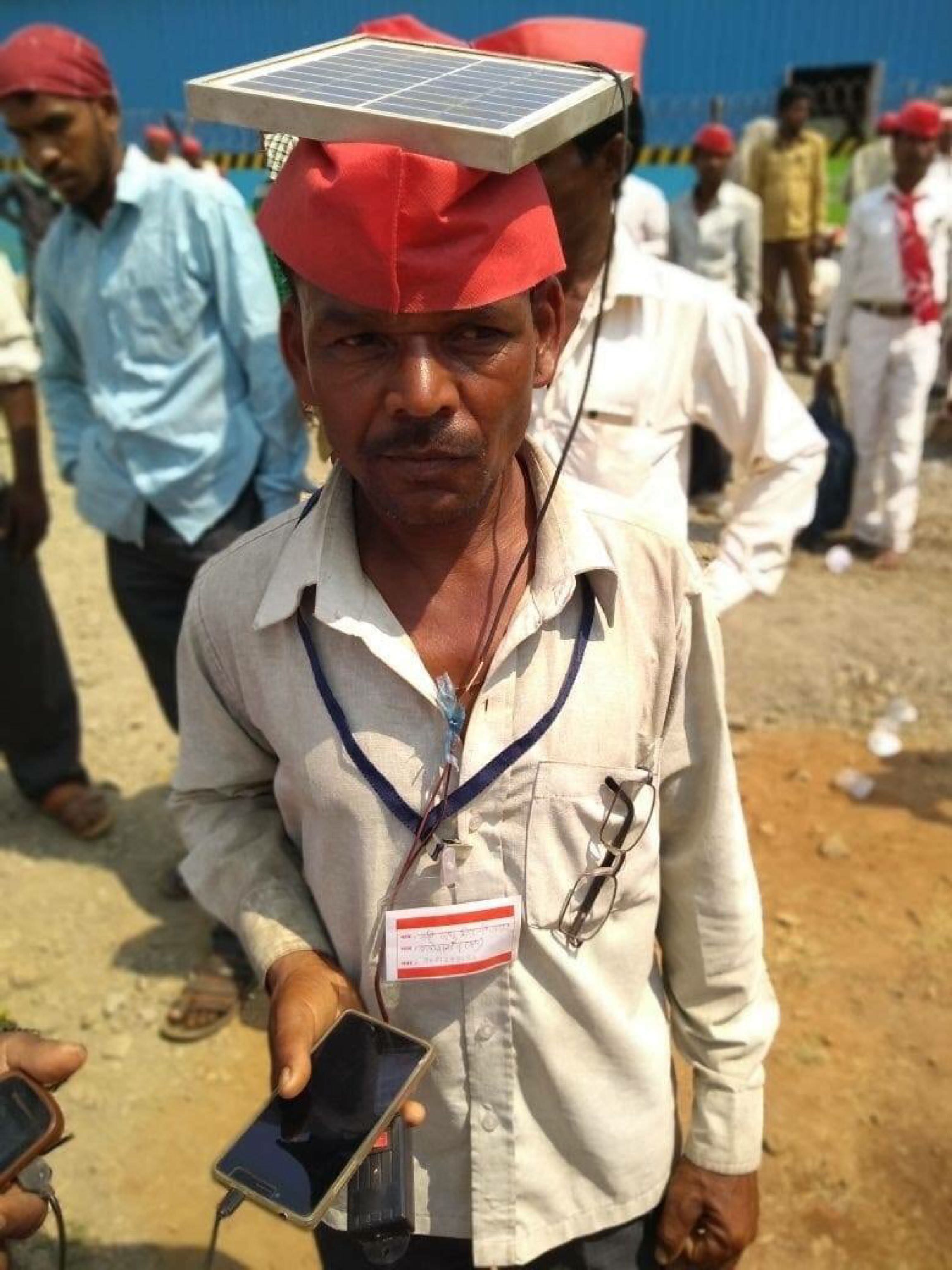 Farmer in India brings along solar panel to charge phones for extra cash.