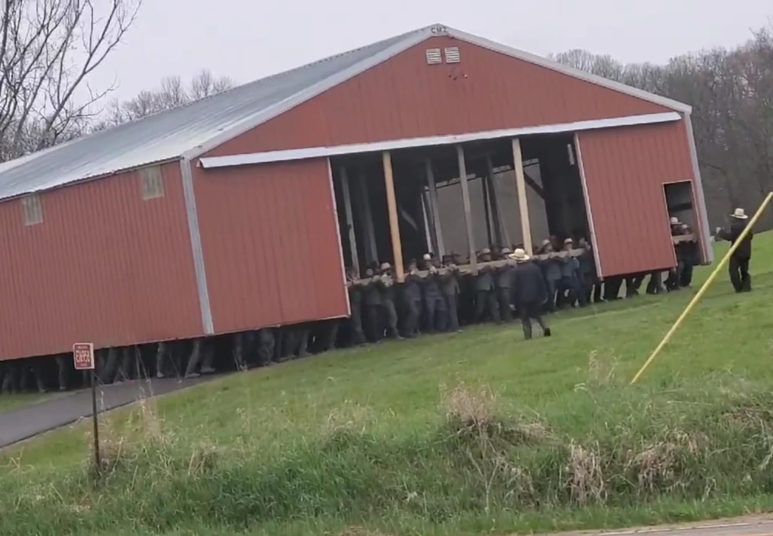 A gaggle of Amish men shifting a barn.