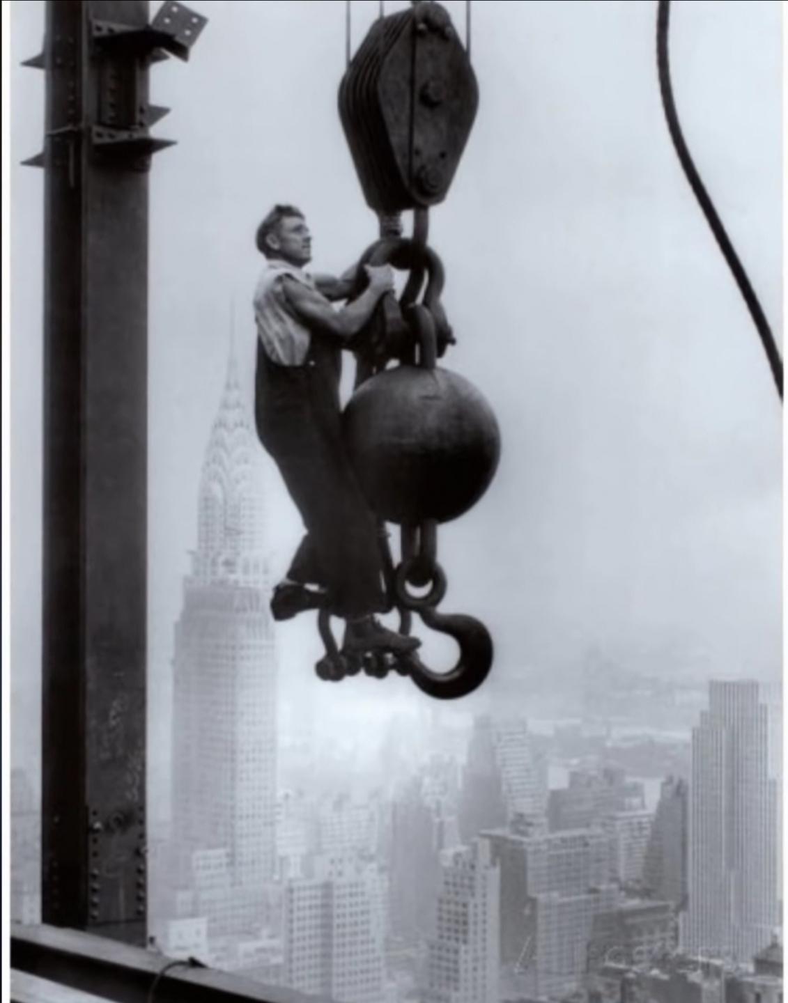 An Iron Worker hanging on to a crane for dear life above New York city, roughly 1926.