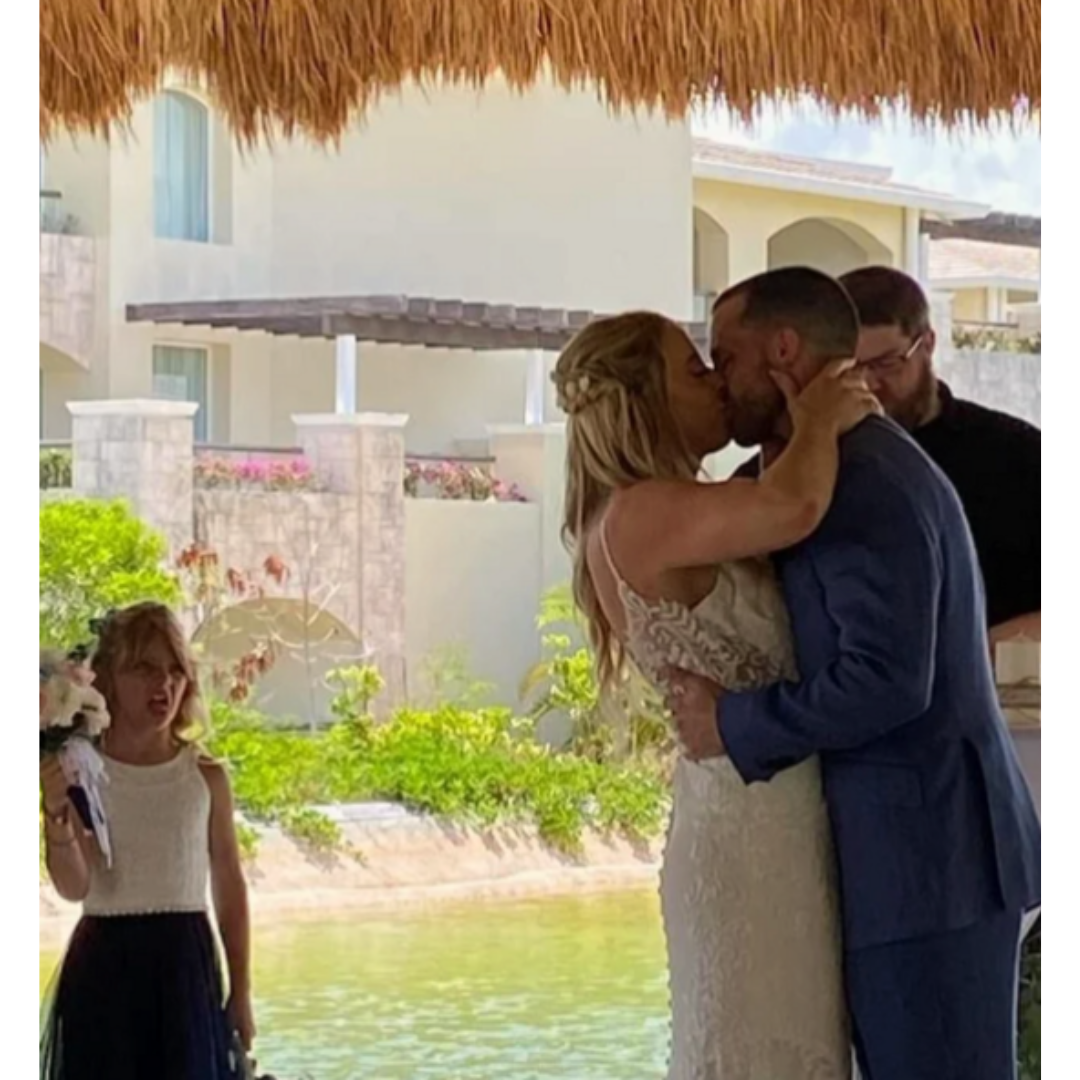 girl sticking her tongue out while couple shares first kiss